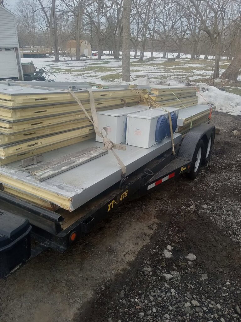 Large panels and equipment loaded onto a trailer for debris removal by Cox Junk & Debris Removal in Buffalo, NY.