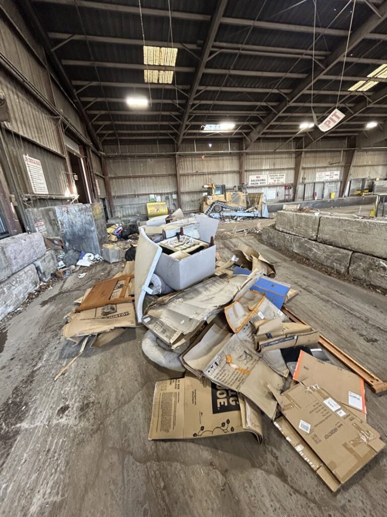 A large pile of cardboard boxes and various debris on the floor of a warehouse, ready for removal by Reno Junk Pros in Reno, NV.