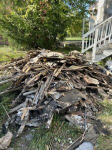 A large pile of construction and demolition debris on the grass, ready for removal by Prestige Junk Removal & Hauling in Detroit, MI.