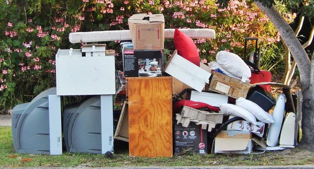 A large pile of household junk and debris placed curbside, ready for pickup in Wichita, KS.
