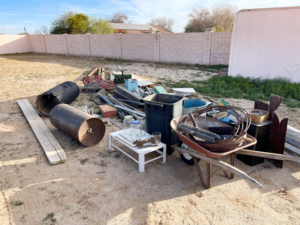 A large pile of miscellaneous junk and debris in a backyard, ready for removal by Junk Junkees in Peoria, AZ.