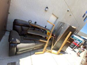A large pile of cardboard boxes, plastic containers, and general debris awaiting removal by Area 661 Hauling in Bakersfield, CA.