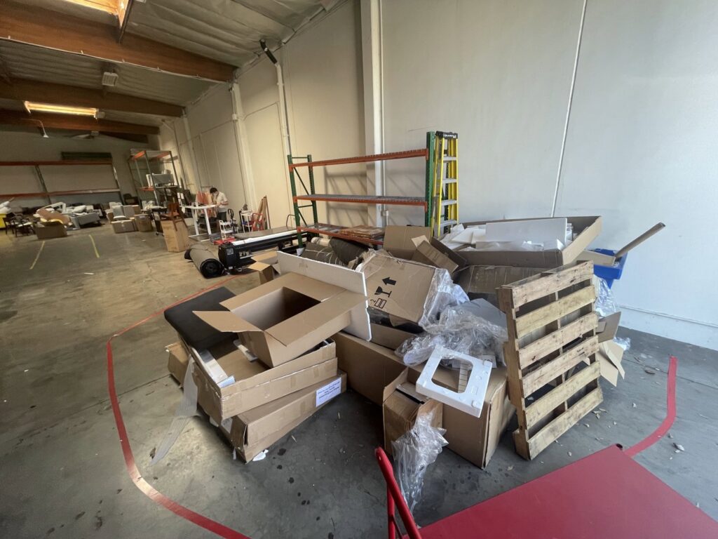 A large pile of cardboard boxes, plastic, and a wooden pallet ready for junk removal by L.A. Junk Squad in Bell Gardens, CA.