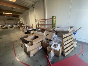 A large pile of cardboard boxes, plastic, and a wooden pallet ready for junk removal by L.A. Junk Squad in Bell Gardens, CA.