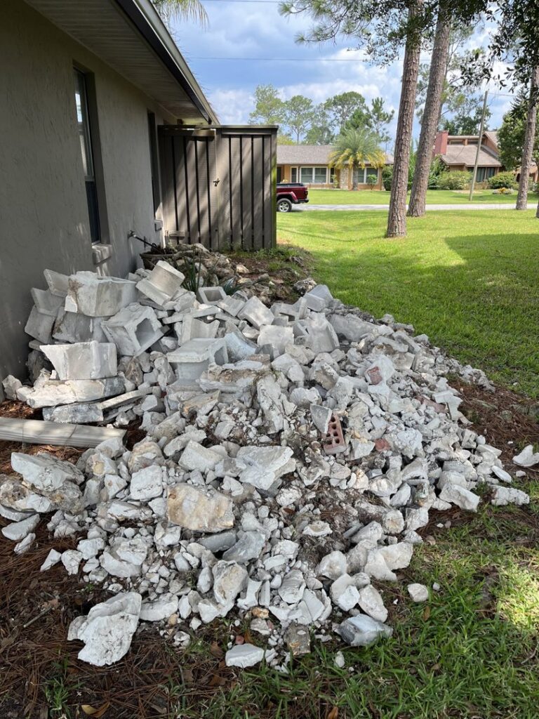 A large pile of concrete debris and cinder blocks awaiting removal by DUMP 4 U Hauling in Jacksonville, FL.