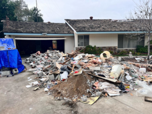 A large pile of construction and demolition debris in front of a home, ready for Republic Junk Removal in San Diego, CA.