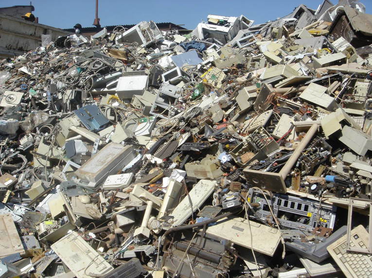 A massive pile of discarded electronic waste, including old computers and monitors, awaiting recycling by E-Grove in Minneapolis, MN.
