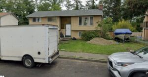 A large pile of household trash, including black and white bags, boxes, and luggage, ready for removal by JUNK IN THEE TRUNK in Kent, WA.