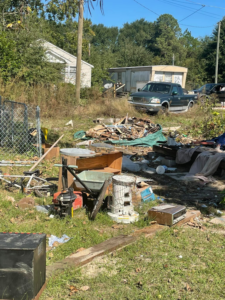 A large pile of mixed junk, debris, and old items in a yard awaiting removal by Ty's touch junk removal,LLC in Fayetteville, NC.