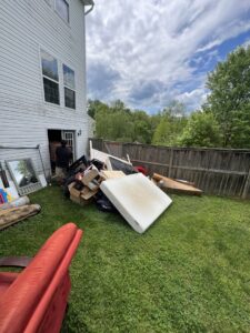 A large pile of household junk and debris in a backyard, ready for removal by Dumpin' Junk in Martinsburg, WV.