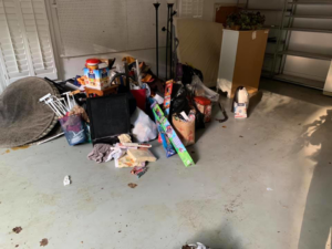 A large pile of miscellaneous junk and clutter in a garage before removal by Hiatts Hauling Junk Removal in Knoxville, TN
