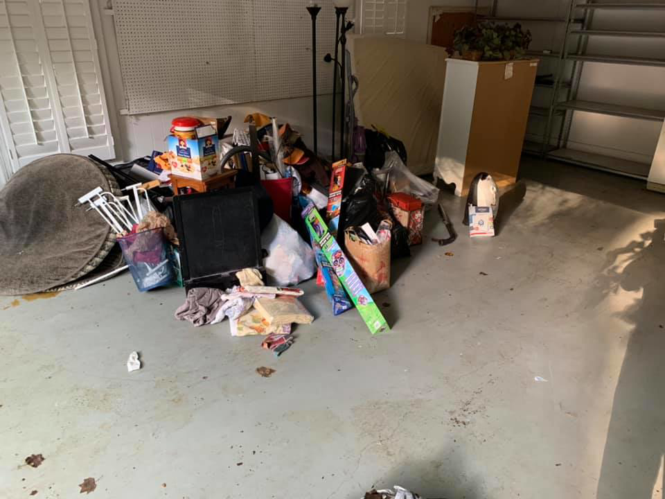 A large pile of miscellaneous junk and clutter in a garage before removal by Hiatts Hauling Junk Removal in Knoxville, TN