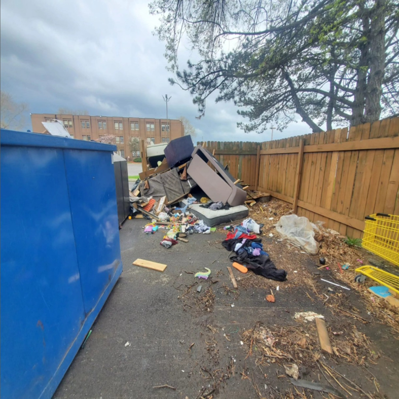 A large pile of household junk and debris next to a fence, ready for removal by 614junkremoval in Columbus, OH.