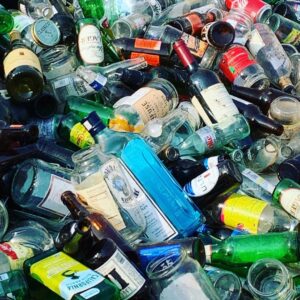 A large pile of mixed glass bottles and jars collected for recycling by Fisher Recycling in Charleston, SC.