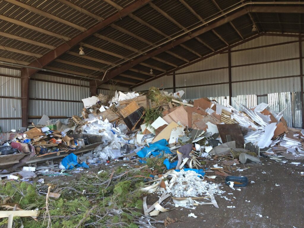 A large pile of mixed construction and general waste inside a facility, handled by A Track-Out Solution in Las Vegas, NV.