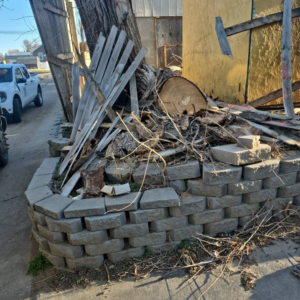 A large pile of wood, branches, and concrete blocks ready for removal by Siouxland Junk Removal in Sioux City, IA.