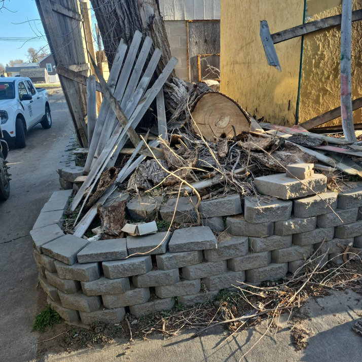 A large pile of wood, branches, and concrete blocks ready for removal by Siouxland Junk Removal in Sioux City, IA.