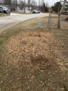 A large pile of wood chips on a grassy area, indicating recent tree service work by Farm Services in Scottown, OH.