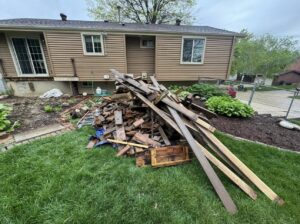 A large pile of wooden planks and disassembled pallets in a residential backyard, ready for removal by Junk-O-Haulics in Westmoreland, TN.