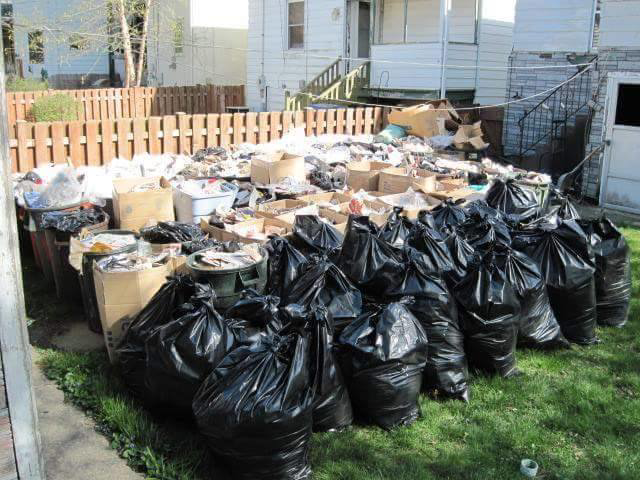 Yard full of trash bags and debris for junk removal by Sabina's Mobile Disposal & Cleaning Service in Cranston, RI.
