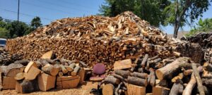 Large piles of cut firewood and logs ready for sale or delivery by Personal Touch Tree Service in Dallas, TX