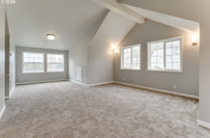 A large remodeled attic space with multiple windows and new carpet by Green Peaks Painting and Remodeling in Elmira, OR