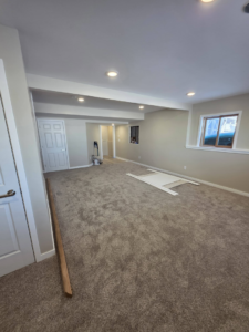 A large remodeled room with new carpet, freshly painted walls, and new doors by Rosenthal Remodeling in Milton, WI.
