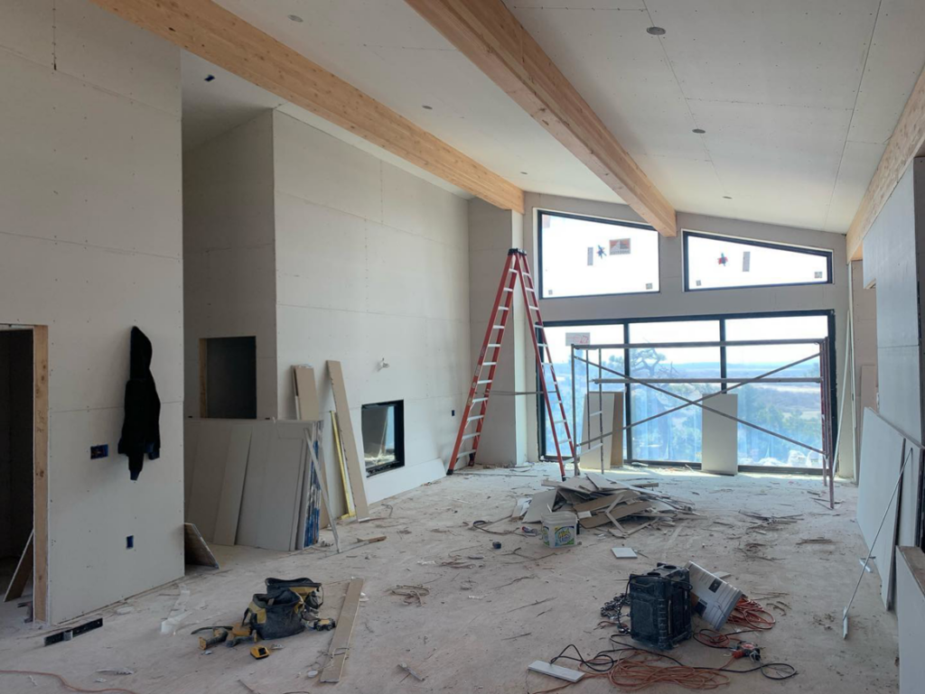 Spacious room with installed drywall, exposed beams, and construction tools, reflecting work by Diamond Drywall in Colorado Springs, CO.