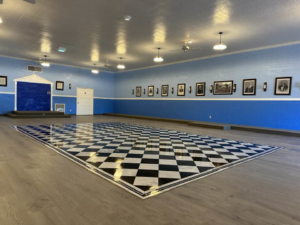 A large room with new black and white checkered flooring and fresh paint by Eminent Renovations in Phoenix, AZ.