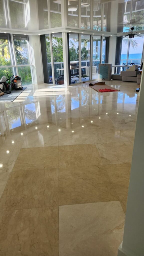 A spacious room featuring beautifully polished marble floors and large windows, a project by Cornerstone Services Management in Miami, FL.
