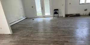 A large room with newly installed laminate wood flooring by SGT. Handyman services RI in Downtown Pawtucket, RI