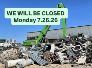 A large pile of scrap metal being processed by an excavator at Great Northwest Recycling in San Antonio, TX