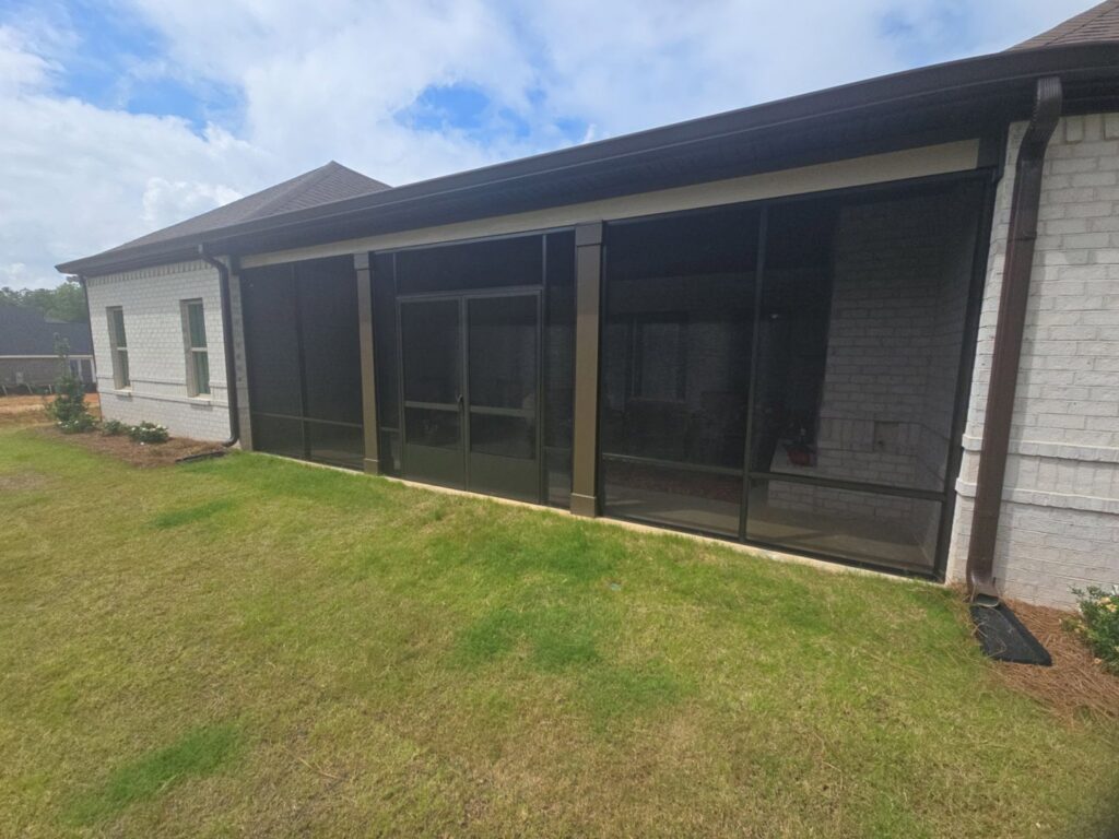 A large screened-in porch on the side of a house by Four Seasons of River City in Columbus, GA.