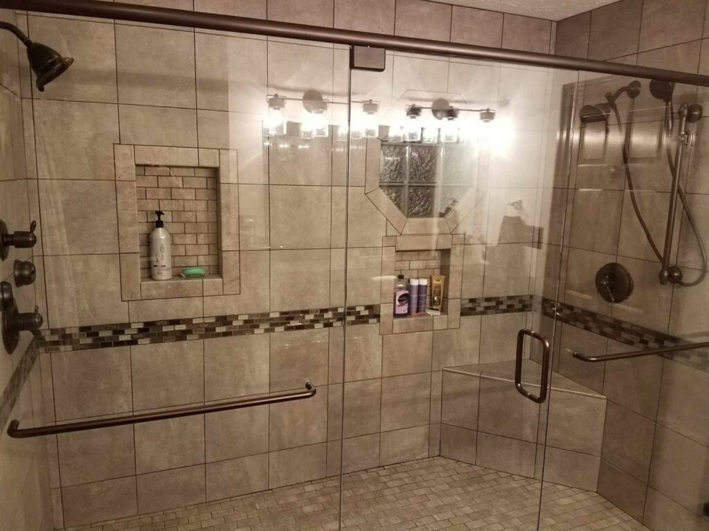 A large, modern tiled shower renovation with glass doors by Indy Renovation in Indianapolis, IN.