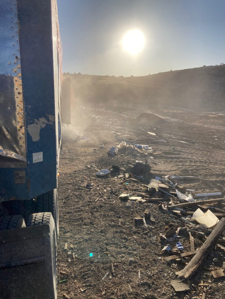 A large truck at a waste disposal site with debris, showing operations for Green Solutions Recycling in Reno, NV.