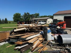 A large pile of wood and construction debris on the ground, ready for removal by All Seasons Junk Removal & Dumpster Services in Center Point, IA.