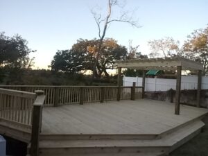 A newly constructed large wooden deck with a pergola, built by Charleston Exteriors in Charleston, SC.
