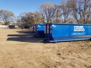 A large yard filled with blue roll-off dumpsters from Payless Rolloff under a clear sky in Albuquerque, NM.