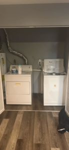 A laundry room with a washer, dryer, and water heater, showcasing appliance installation or repair services by Primo Services LLC in Cincinnati, OH.