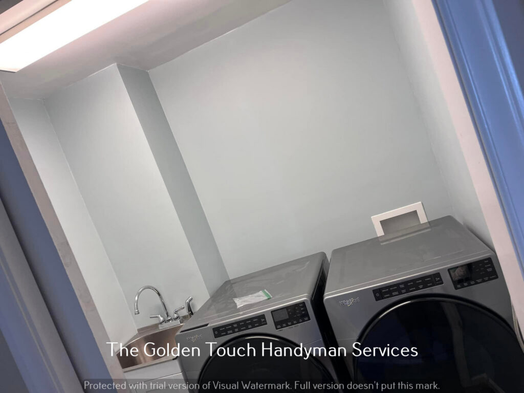 A newly renovated laundry room with washer, dryer, and utility sink installed by The Golden Touch handyman services in Huntington, WV.