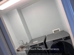 A newly renovated laundry room with washer, dryer, and utility sink installed by The Golden Touch handyman services in Huntington, WV.