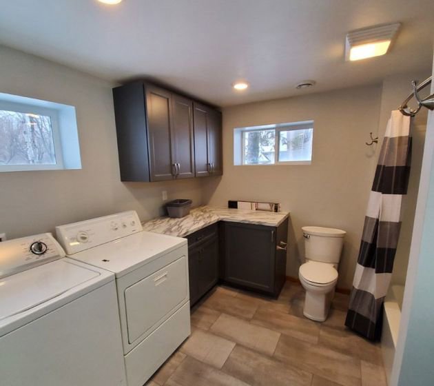 A remodeled laundry room and bathroom combination with new cabinets and fixtures by Boisen Remodeling LLC in Appleton, WI.