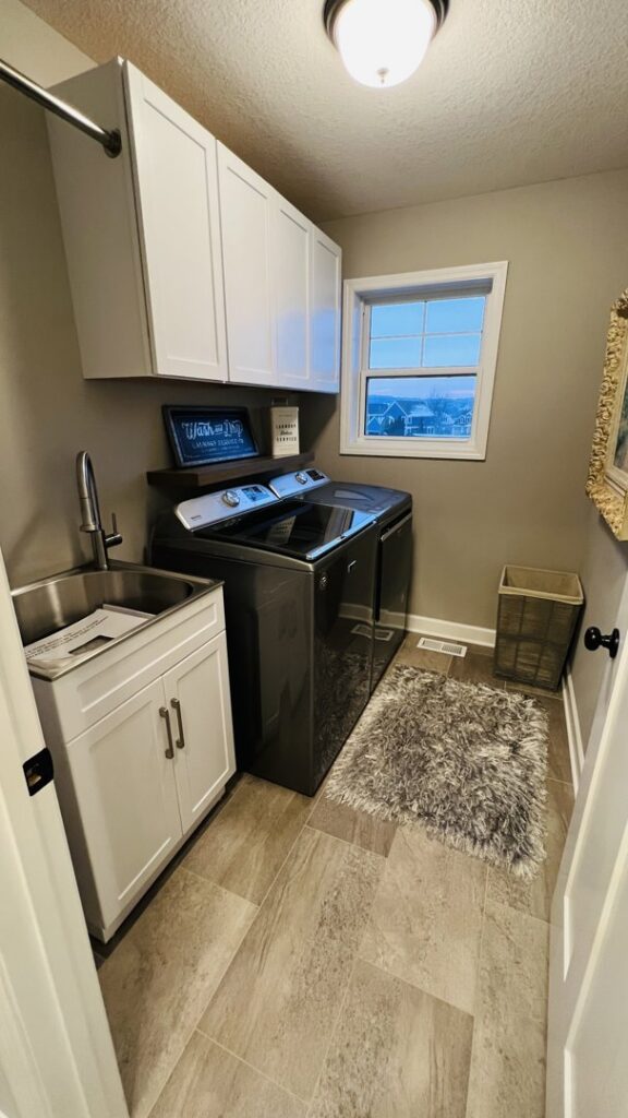 A renovated laundry room with new cabinets, sink, and updated flooring by Clear Choice Handyman LLC in Woodbury, MN.