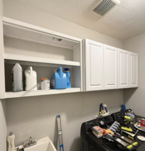 Newly installed white cabinets and shelving in a laundry room by DeLeon Contracting LLC in San Antonio, TX.