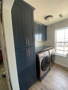 New dark blue laundry room cabinets installed by M&M Home Builders, LLC in Richmond, VA.