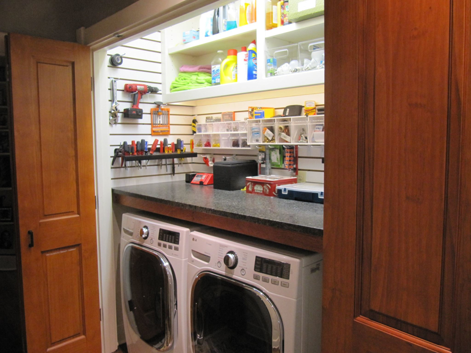 A renovated laundry room and utility space with washer, dryer, and custom storage by Jackson Construction in Oak Hills Place, LA