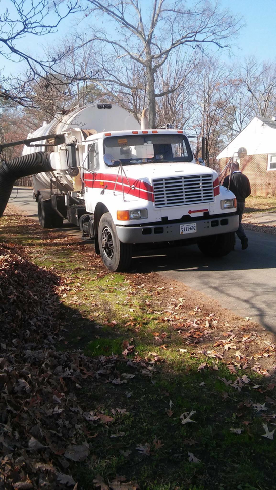 A large leaf vacuum truck parked at a residential job site for Leaf It To Me Your Leaf Authority- Leaf Removal in Richmond, VA.