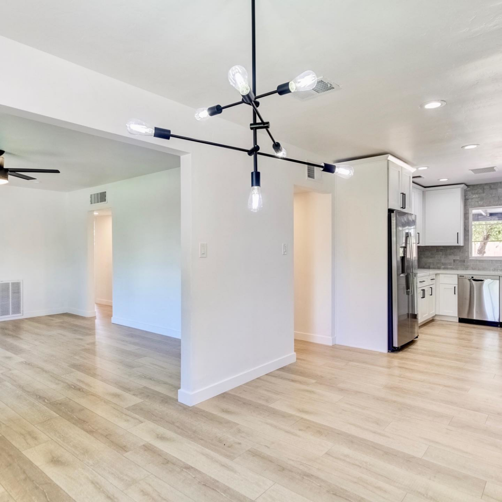 Professional installation of modern light fixtures and new flooring in an open-concept living space by RHS Builders in Scottsdale, AZ.