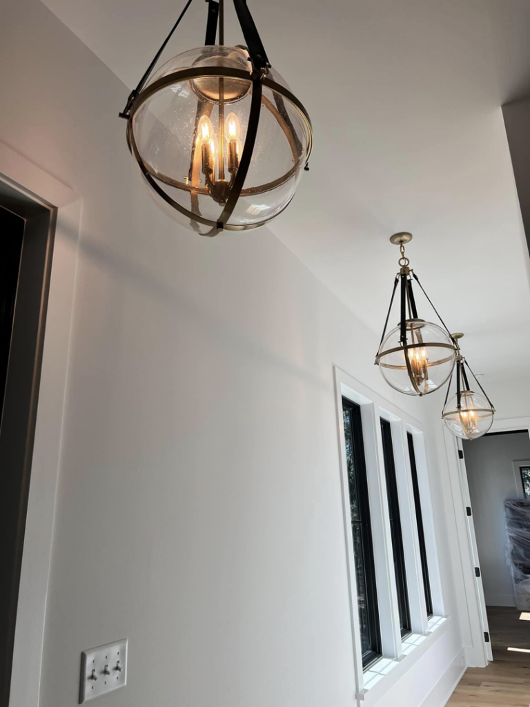Three decorative globe light fixtures installed in a hallway by Coleman Builders in Mount Pleasant, SC