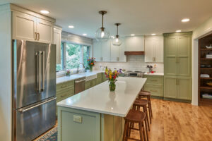 A beautiful kitchen remodel featuring light green and white cabinets and a large island by North Shore Kitchens in Pittsburgh, PA.